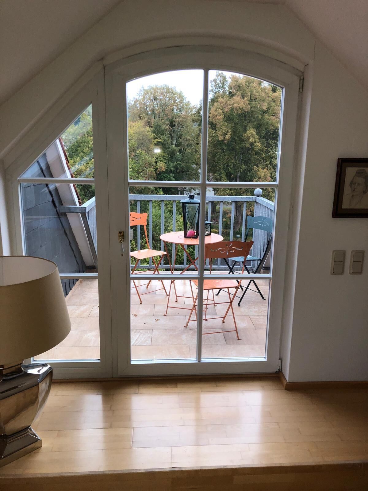 Une pièce dotée d’une grande porte-fenêtre coulissante qui donne sur une terrasse extérieure avec une table et des chaises.