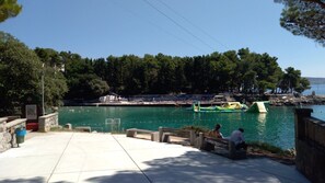 A waterfront area with a pool, benches, and a small boat. - Apartment DiSente °2 with Sea view  (Krk)