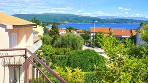A coastal residential area with houses, a clear blue sea, and mountains in the background. - Apartment DiSente °2 with Sea view (Krk)