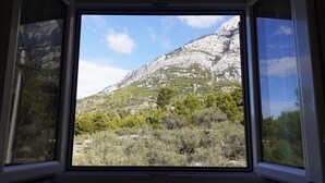 A window view of a mountainous landscape with rocky terrain and sparse vegetation.