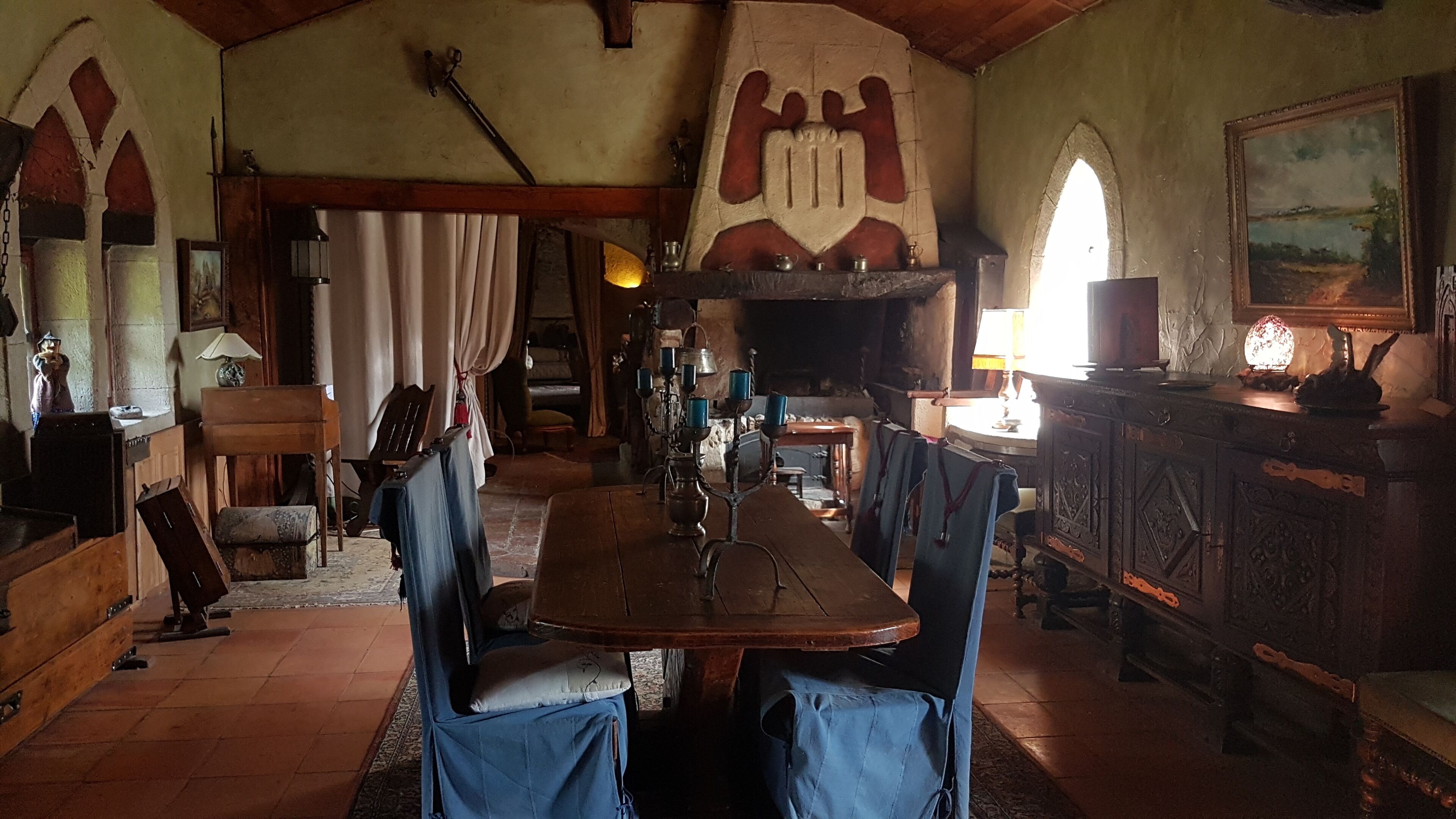 A rustic dining room with a wooden table and blue upholstered chairs.