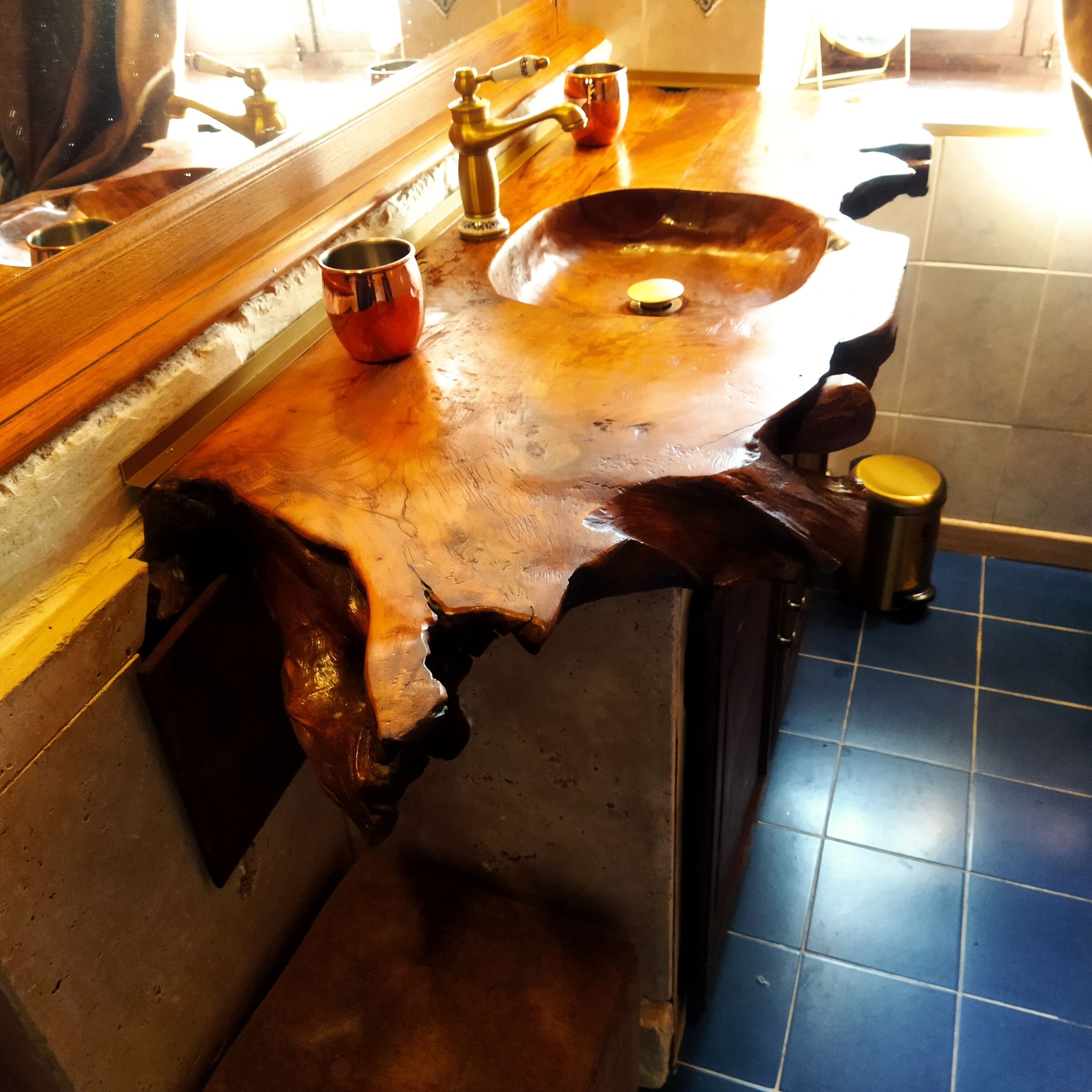 Ein Badezimmer mit einem Holzkosmetikschrank, einem Waschbecken und einem Spiegel.