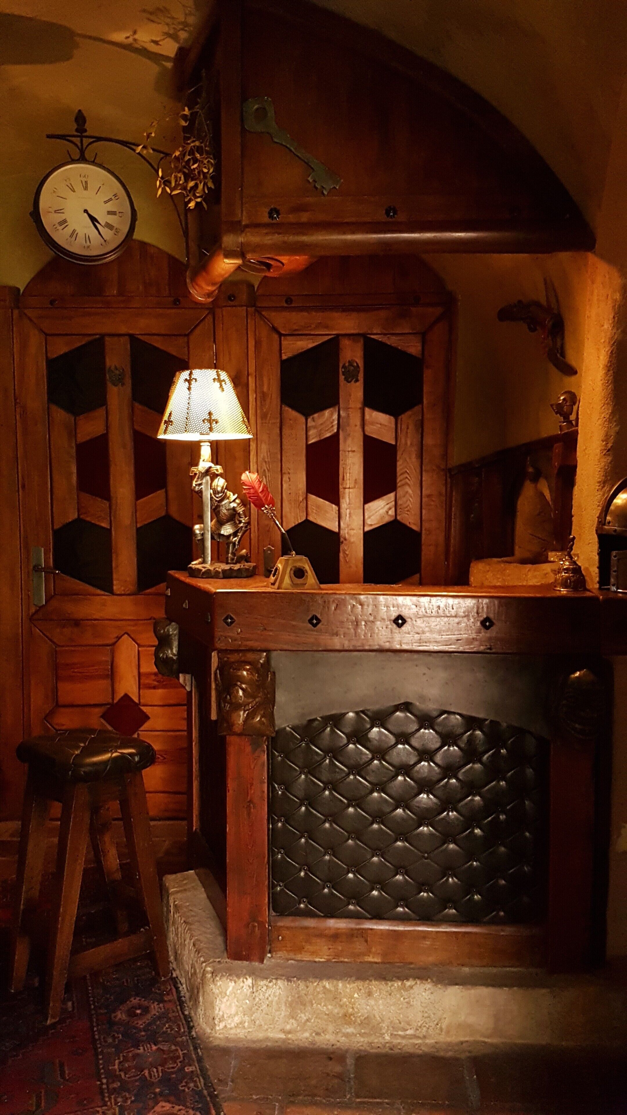 Une pièce chaleureuse avec un meuble en bois, une horloge et une lampe.