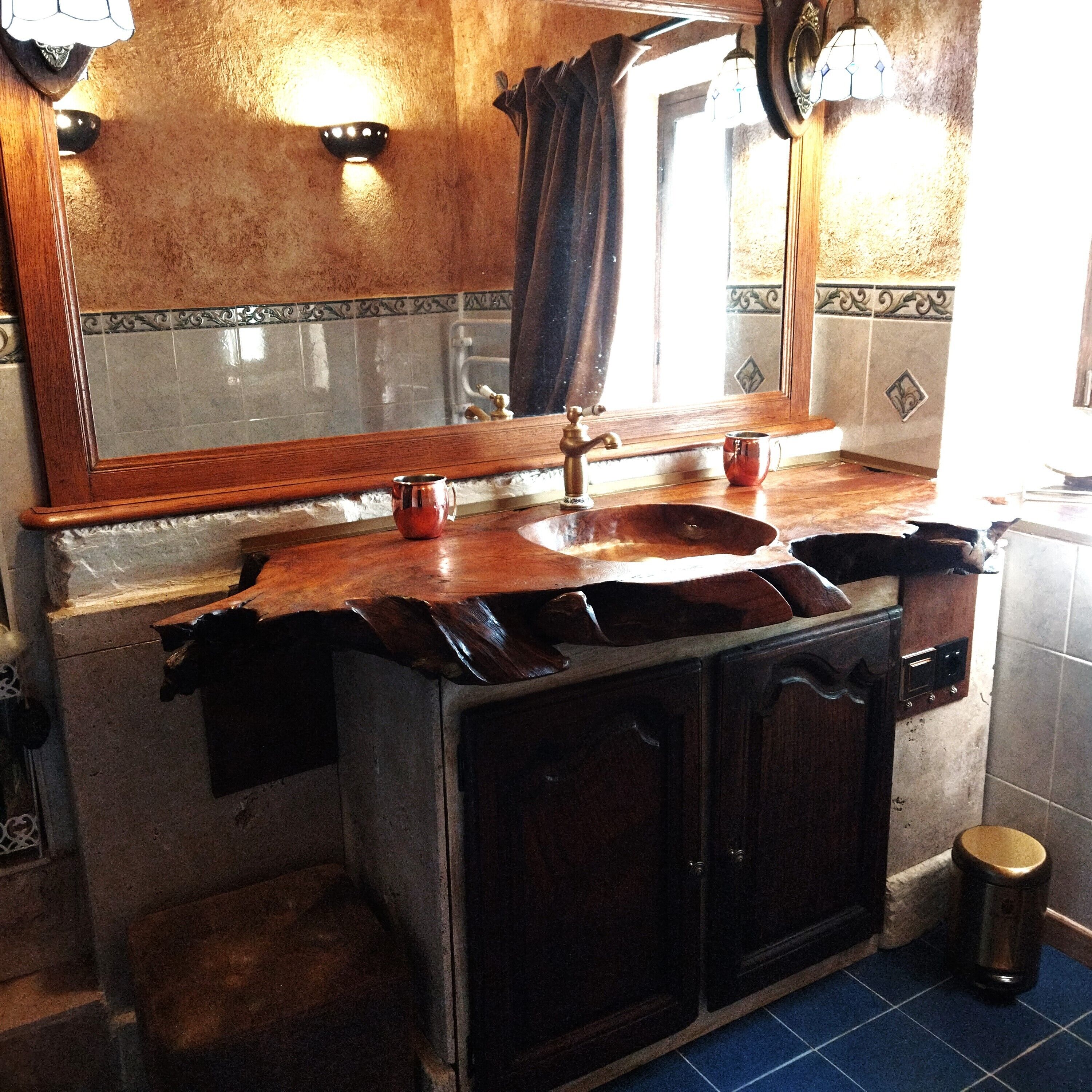 Un baño con tocador de madera, un lavabo y un espejo.