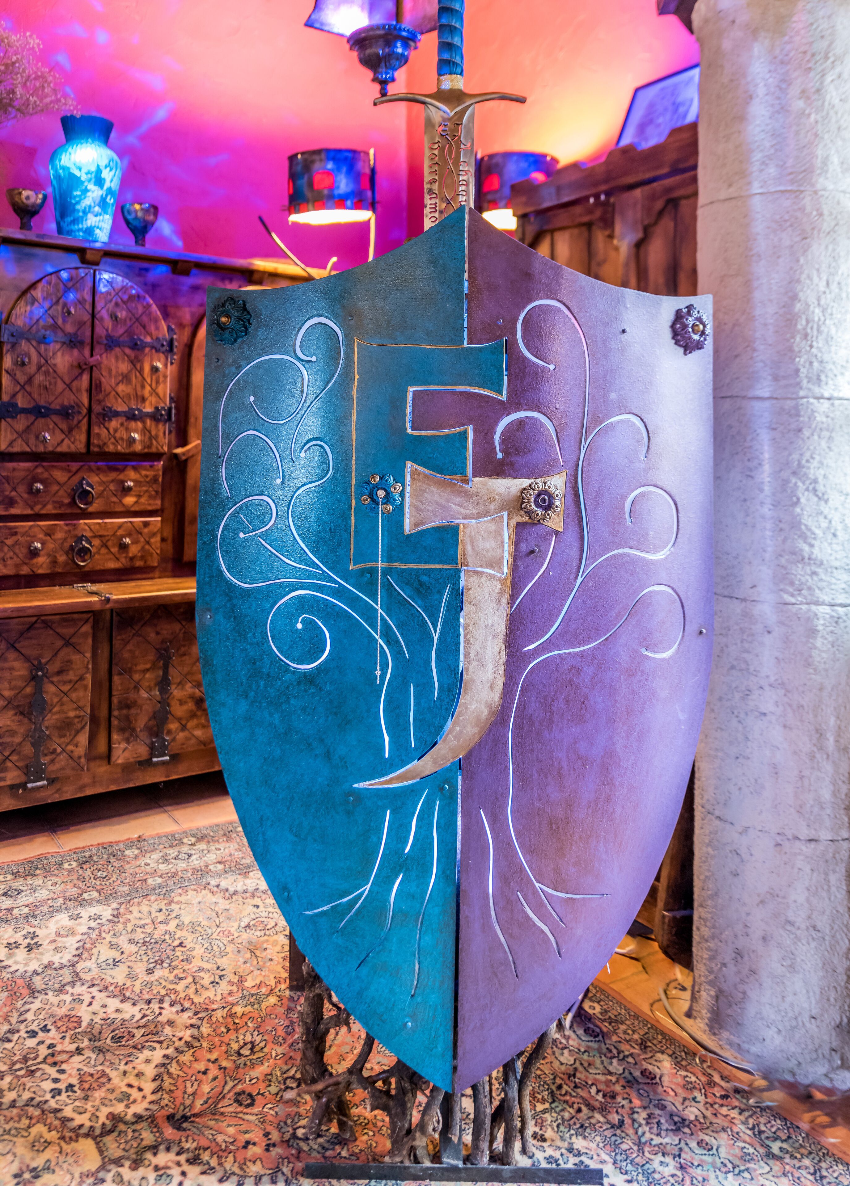 A shield-shaped decorative piece with intricate designs, mounted on a stand.