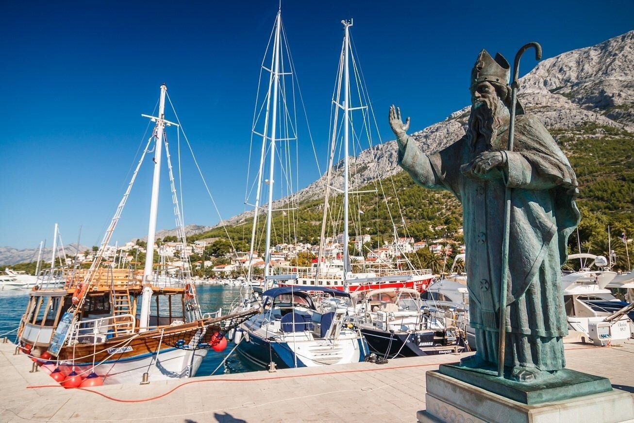 Un puerto con barcos y una estatua.