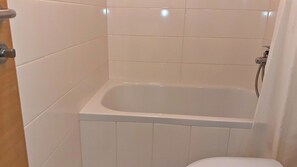 Bathtub, towels, soap, toilet paper