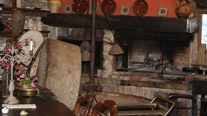 Ein rustikales Interieur mit Kamin, Holzmöbeln und verschiedenen Dekoartikeln.