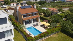 A modern two-story house with a swimming pool, outdoor seating, and a garden. - Luxury villa with heated pool by the sea in a quiet area (Pula - Pomer)
