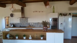 A modern kitchen with a central island, white cabinetry, and a tiled backsplash.