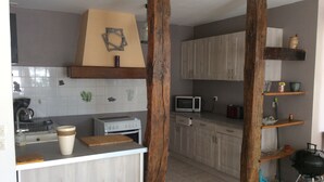 A kitchen with wooden cabinets, a microwave, a stove, and a coffee maker.
