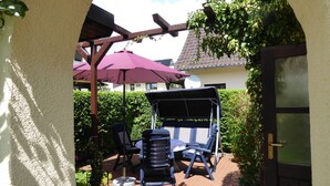 An outdoor patio area with a covered seating area, a swing chair, and a pergola. - cozy functional apartment (Lauterbach)