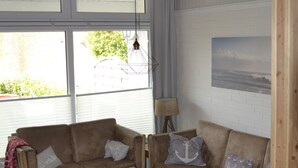 Ein gemütliches Wohnzimmer mit zwei Sofas, einem Couchtisch und einer Lampe.