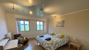 Un dormitorio con cama, escritorio, silla y ventana.