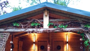 A wooden cabin with a dining area featuring four chairs and a table. - You will find relaxation and a peaceful idyll here in the Apartment-Feldsteingarten  (Luckau (Wendland))