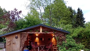 A wooden cabin with a dock leading to a pond with koi fish. - You will find relaxation and a peaceful idyll here in the Apartment-Feldsteingarten  (Luckau (Wendland))
