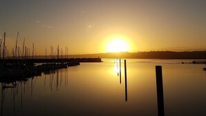 A calm body of water reflecting the sunset with a marina on the left. - Apartment *** approved 2018 - Trestraou Beach (Perros-Guirec)