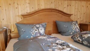 Een kamer met houten lambrisering en een bed met bloemenbedrukking.