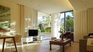 A modern living room with a flat-screen TV, a coffee table, and a sofa. - Quiet GF apartment at the water, V&A waterfront, overlooking Table Mountain, free WiFi (Cape Town)