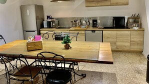 Een compacte keuken met een houten aanrecht, een ingebouwde vaatwasser en een magnetron.