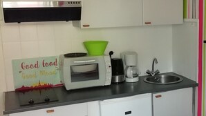 A compact kitchen with white cabinets, a stainless steel range hood, a toaster, a coffee maker, and a sink. - STUDIO 1 PERSON - CENTER LA BAULE (La Baule)