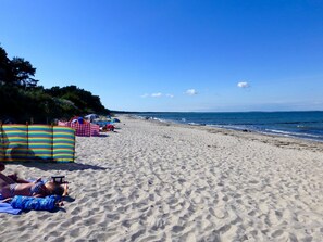 A sandy beach with umbrellas and beach chairs. - Close to the beach, family-friendly, sustainable, sauna, fireplace, garden, e-charging station (Glowe)