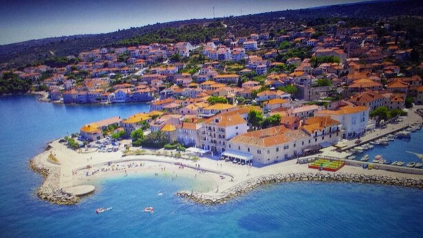 An aerial view of a coastal town with a central building complex, a beach, and a marina. - few minutes to the beach (Postira)