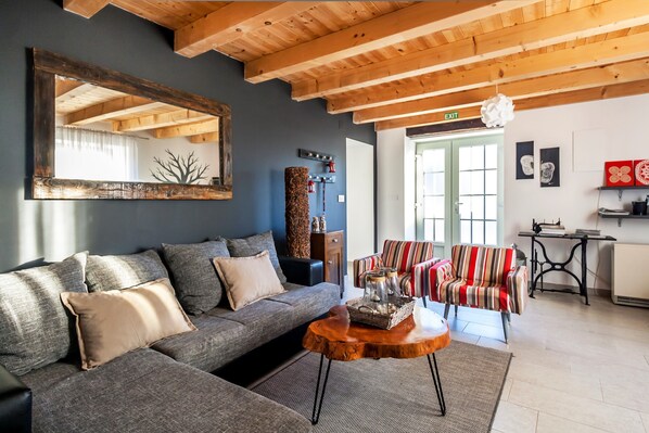 A modern living room with a grey sofa, a wooden coffee table, and a striped armchair. - Villa ****, barbecue, free wifi, suitable for family (Štokovci)
