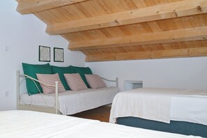 A bedroom with two beds, a sloped ceiling, and a wall-mounted power outlet. - Villa ****, barbecue, free wifi, suitable for family (Štokovci)