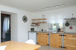 A modern kitchen with wooden cabinets, a built-in dishwasher, and a window providing natural light. - Villa ****, barbecue, free wifi, suitable for family (Štokovci)