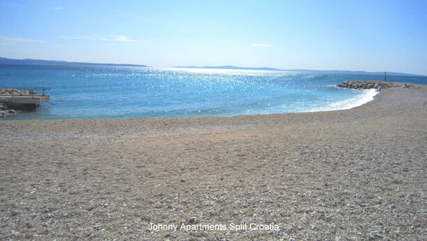 A beach with a rocky shoreline and a clear blue sky.