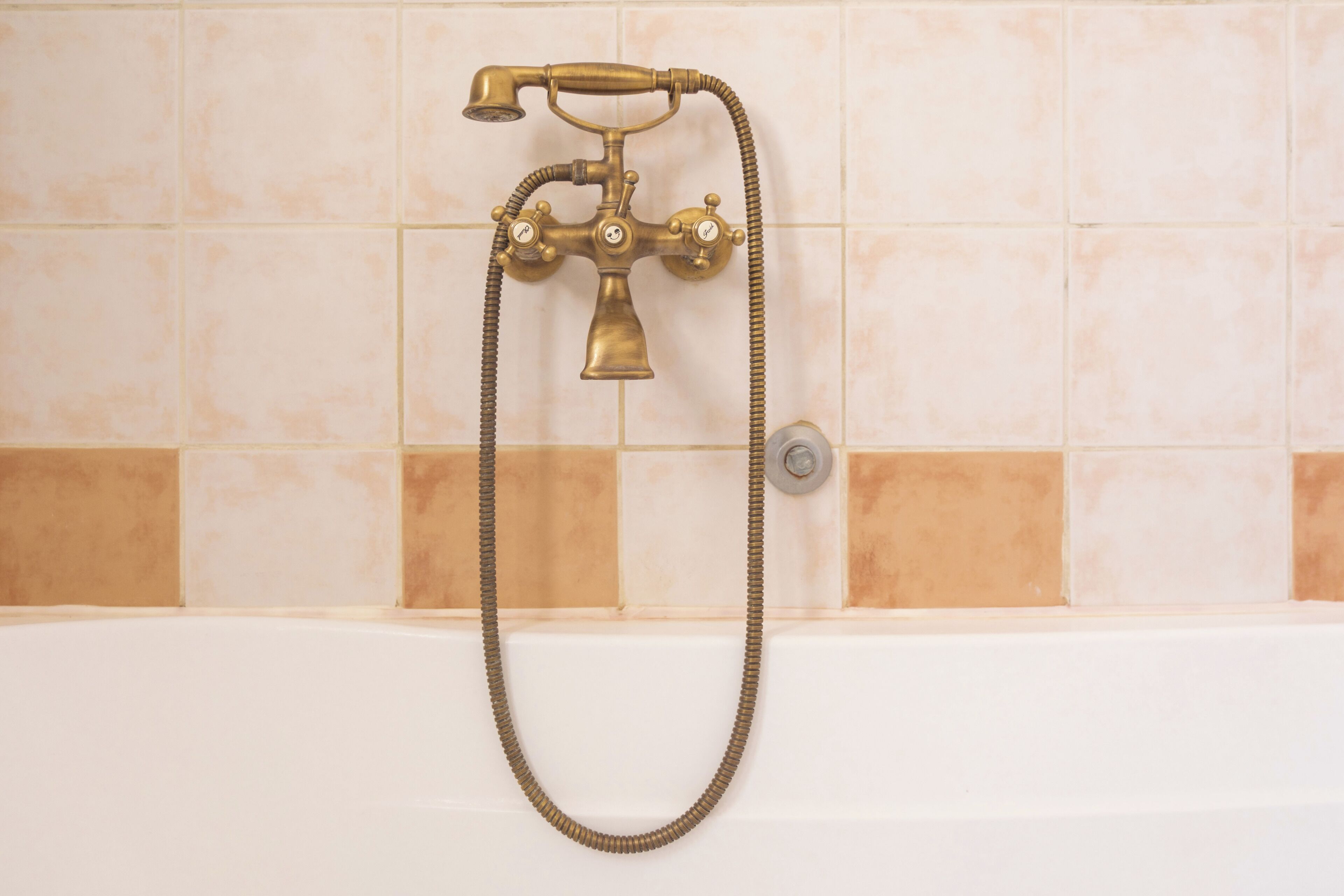 Ein Badezimmer mit einer Vintage-Duschbrause und einem Brauseschlauch aus Messing.