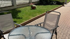 A round glass table with metal chairs, surrounded by a brick patio. - Colmar, close to the center, charming 3-room apartment in a quiet area (Colmar)
