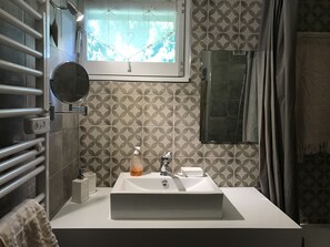 A bathroom with a white sink, a mirror, a window with a view of trees, a towel rack, and a shower curtain. - Appartement 65m2 esprit Chalet. Parking. Balcon (Cauterets)
