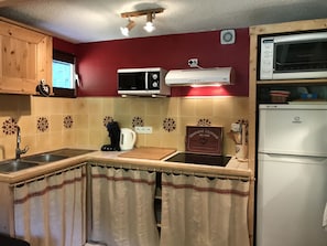 Une cuisine équipée d’un four à micro-ondes, d’une cuisinière, d’un évier et d’un réfrigérateur.