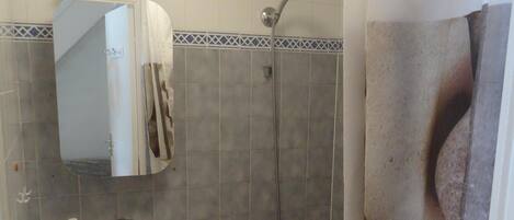 Ein Badezimmer mit Waschbecken, Spiegel, Dusche und Badewanne.