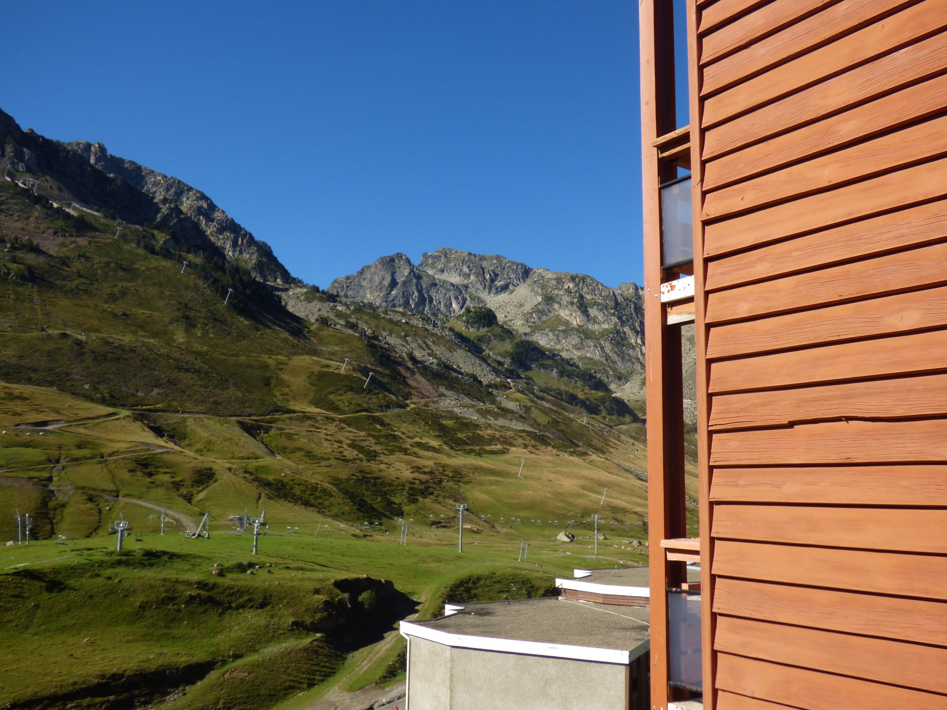 Paisaje montañoso con vistas a una construcción de madera.