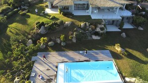 An aerial view of a modern house with a swimming pool, surrounded by landscaped gardens and a deck area. -  MODERN VILLA 10 PERONNES SWIMMING POOL 10MN FROM THE BEACH AND SPERONE GOLF VIEW  (Bonifacio)