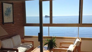 A room with a view of the sea, a sofa, a table, and a chair. - Apartment facing the sea. In the center of the Poniente Beach. WIRELESS. Swimming pool (Benidorm)