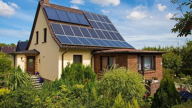 A house with a sloped roof and solar panels.