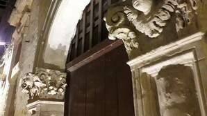 Ein verziertes Gebäudeeingang mit einer Holztür und dekorativen Steinmetzarbeiten.