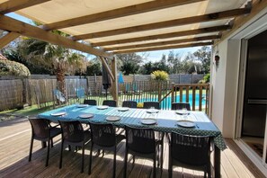 Relax in the shaded patio area, complete with a table for four and comfortable seating.
