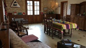 A dining area with a table set for four, wooden chairs, and a colorful tablecloth.