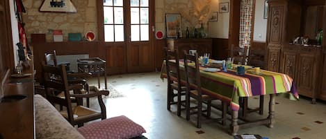 A dining area with a table set for four, wooden chairs, and a colorful tablecloth.