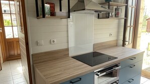 A modern kitchen with a wooden countertop, built-in oven, and blue cabinets.
