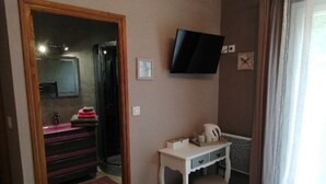 A hotel room with a bed, a desk, a television mounted on the wall, and a bathroom visible through an open door. - Bed and Breakfast Le Chêne (Mauzens et Miremont)