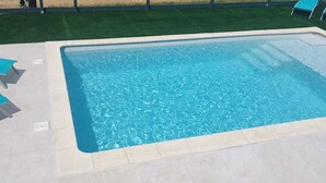A rectangular swimming pool with clear blue water, surrounded by a tiled deck. - Bed and Breakfast Le Chêne (Mauzens et Miremont)