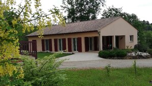 A single-story building with a tiled roof, a covered porch, and a gravel driveway. - Bed and Breakfast Le Chêne (Mauzens et Miremont)