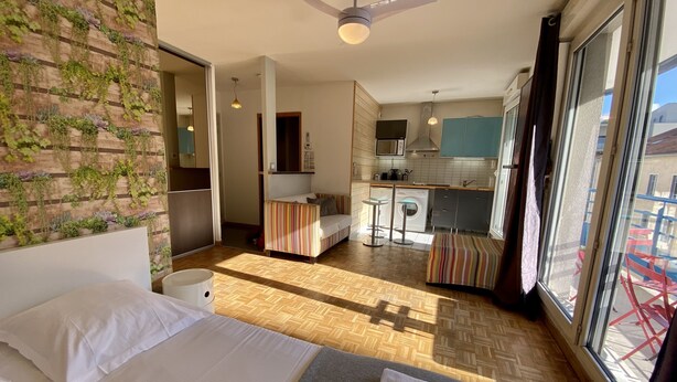 Ein Hotelzimmer mit Bett, einer kleinen Küchenzeile, einem Essbereich und Blick ins Freie.