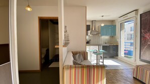 Eine moderne Wohnung mit Küche, Essbereich und einem kleinen Wohnzimmer.